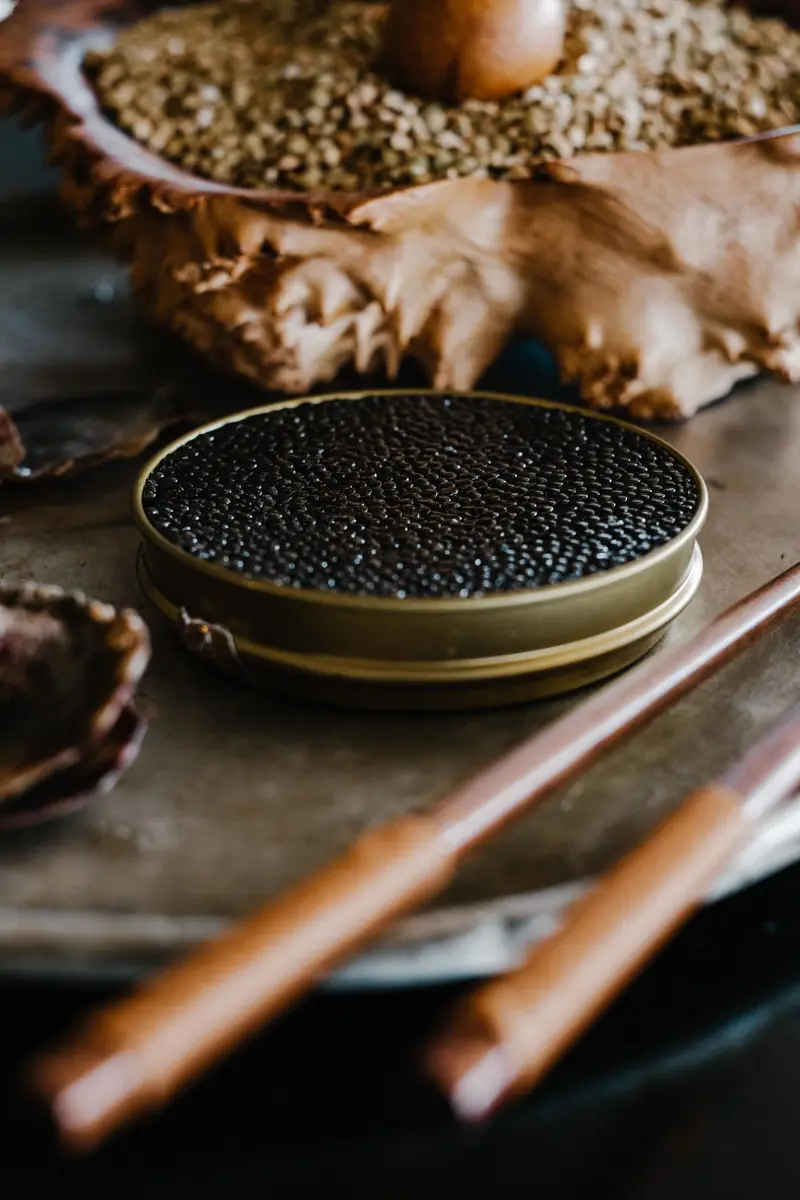 Caviar served with chopsticks in a dark setting